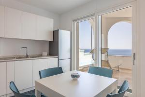una cucina con tavolo e sedie e vista sull'oceano di Marinaia Archi a Marittima