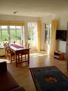 a living room with a dining room table and chairs at Mühlenblick in Dänschendorf