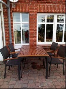 a wooden table and chairs in front of a brick building at Mühlenblick in Dänschendorf