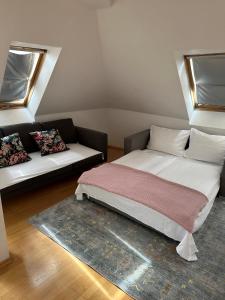 a bed and a couch in a room at Hotel Der Tannenbaum in Munich +21 photos