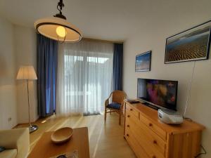 - un salon avec une télévision sur une commode en bois dans l'établissement Sundby, à Lemkenhafen auf Fehmarn