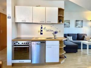 une cuisine avec des armoires blanches et un comptoir dans l'établissement Kajüte 4, à Lemkenhafen auf Fehmarn