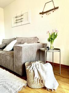 un salon avec un canapé et une table avec des fleurs dans l'établissement Havnkoje, à Westerbergen