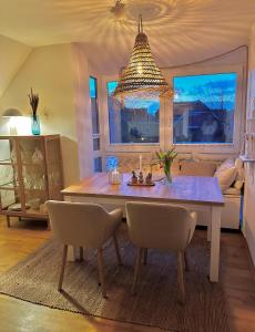 une table à manger avec des chaises et un lustre dans l'établissement Havnkoje, à Westerbergen