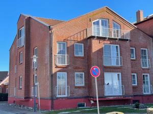 a red brick building with a sign in front of it at Orth A3 - Hafentraum in Orth