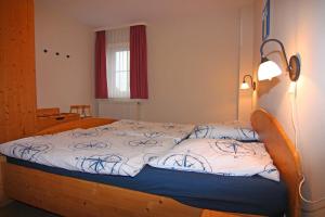 ein Schlafzimmer mit einem Holzbett mit einer weißen Bettdecke in der Unterkunft Orth A6 in Orth