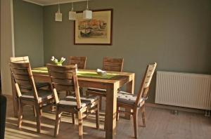a dining room with a wooden table and chairs at Orther Hafenblick in Orth