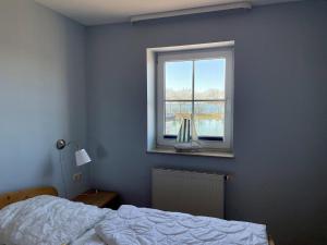 a bedroom with a bed and a window at Orth B11 - Bestlage mit Hafenblick in Orth