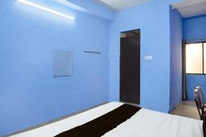 a blue room with a bed and a door at HOTEL O PRAGYA 6 in Raipur