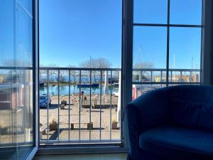 a living room with a window looking out at a marina at Orth B11 - Bestlage mit Hafenblick in Orth +1 photo