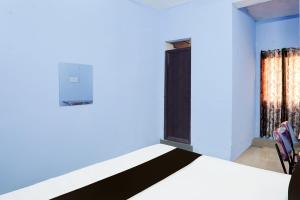 a bedroom with a bed and a door with a window at HOTEL O PRAGYA 6 in Raipur