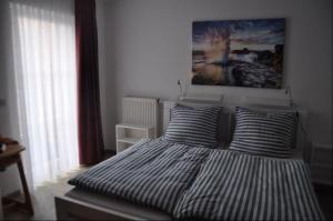 - une chambre avec un lit avec deux oreillers et un tableau dans l'établissement Orth C24, à Orth