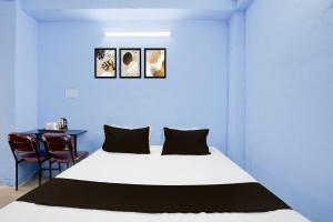 a bedroom with a white bed and a table at HOTEL O PRAGYA 6 in Raipur