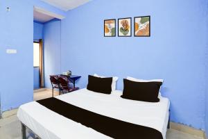 a blue bedroom with a large bed with black pillows at HOTEL O PRAGYA 6 in Raipur