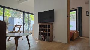 un salon avec une télévision à écran plat sur un mur dans l'établissement Le MazeL, meublé de tourisme 2 à 4 personnes, à Avignon