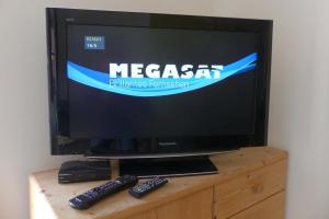 a television with two remote controls sitting on a dresser at Orth - E37 in Orth