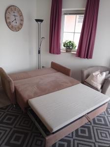 a bed and a couch in a room with a clock at Orth - E37 in Orth