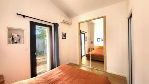 une chambre avec un miroir et un lit dans une pièce dans l'établissement Le MazeL, meublé de tourisme 2 à 4 personnes, à Avignon