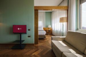 a living room with a couch and a bedroom at Exe Majestic in Naples