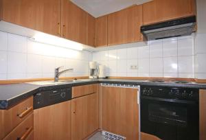 a kitchen with wooden cabinets and a black dishwasher at Orth A4 in Orth