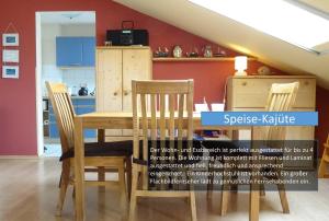 a dining room table with two chairs and a cabinet at Hafenblick in Orth