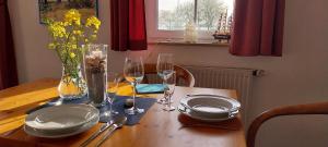 a table with plates and glasses and a vase of flowers at Blue Water in Orth