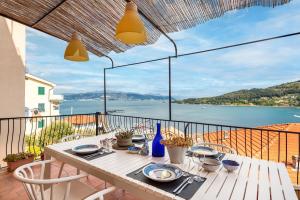 a table on a balcony with a view of the water at Porto sea view-Terrace & AC in Portovenere