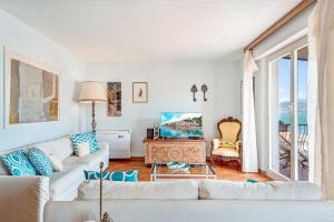 a living room with a white couch and a tv at Porto sea view-Terrace & AC in Portovenere