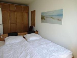a bedroom with a white bed and a cabinet at Schöne Aussicht in Orth