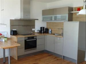 a kitchen with stainless steel appliances and a wooden table at Schöne Aussicht in Orth +4 photos