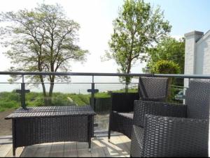 a balcony with wicker chairs and a view of the ocean at Schöne Aussicht in Orth