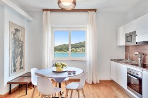 a kitchen with a table and chairs and a window at Porto sea view-Terrace & AC in Portovenere