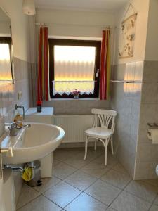a bathroom with a tub and a sink and a window at Orth Poststraße 8 EG in Orth