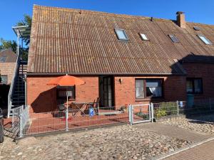 a brick house with an orange umbrella in front of it at Orth Poststraße 8 EG in Orth