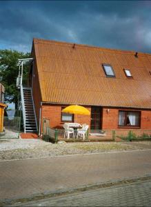 a house with a table and an umbrella in front of it at Orth Poststraße 8 EG in Orth