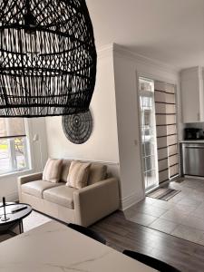 ein Wohnzimmer mit einer Couch und einem Kronleuchter in der Unterkunft MC'S nB in Saint-Sauveur-des-Monts