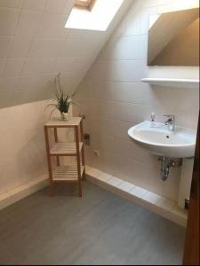 a bathroom with a sink and a mirror and a chair at Lichtblick in Petersdorf auf Fehmarn