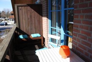 a chair sitting on a porch next to a door at Lichtblick in Petersdorf auf Fehmarn