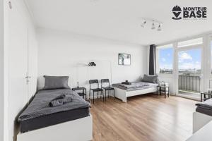 Una habitación blanca con dos camas y un sofá. en MONTEUR - Unterkunft für bis zu 6 Personen in 63452 Hanau - HU13, en Hanau am Main