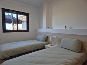 a bedroom with two beds and a window at casa hilo dorado in Águilas