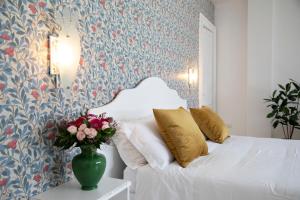 a bedroom with a bed and a vase of flowers on a table at Relais San Martino - Salento in Taviano +92 photos