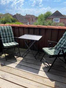 2 sedie e un tavolo su una terrazza di Welcome a Petersdorf auf Fehmarn