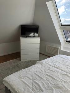 una camera con letto e TV su un comò di Welcome a Petersdorf auf Fehmarn