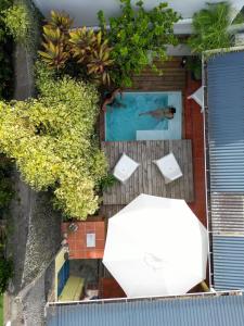 an overhead view of a swimming pool with a white umbrella at La Maison Jaune - Swimming pool & beach access 50 m away in Saint-Pierre