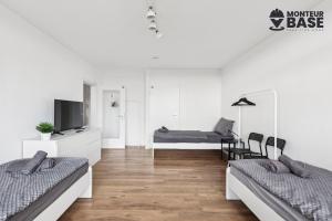 Habitación blanca con 2 camas y TV. en MONTEUR - Unterkunft für bis zu 6 Personen in 63452 Hanau - HU13, en Hanau am Main 4 fotos más