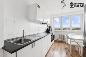 Una cocina blanca con un fregadero y una mesa. en MONTEUR - Unterkunft für bis zu 6 Personen in 63452 Hanau - HU13, en Hanau am Main