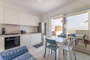 een keuken en eetkamer met een tafel en stoelen bij Marinaia Gran Vista Mare in Marittima