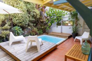 a patio with a table and chairs and a swimming pool at La Maison Jaune - Swimming pool & beach access 50 m away in Saint-Pierre