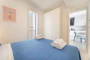 een slaapkamer met een blauw bed met handdoeken erop bij Marinaia Gran Vista Mare in Marittima +12 foto's