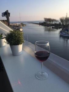un bicchiere di vino seduto su un tavolo con vista sull'acqua di meerBLICK a Orth Altre 3 foto